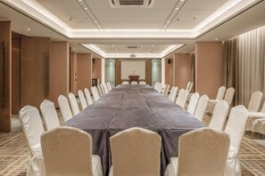 A conference room with a long table and chairs, a podium, and a carpeted floor. - Huayi Hotel (Chongyang)