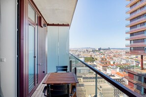 Enjoy the city view from this balcony with a table and two chairs.
