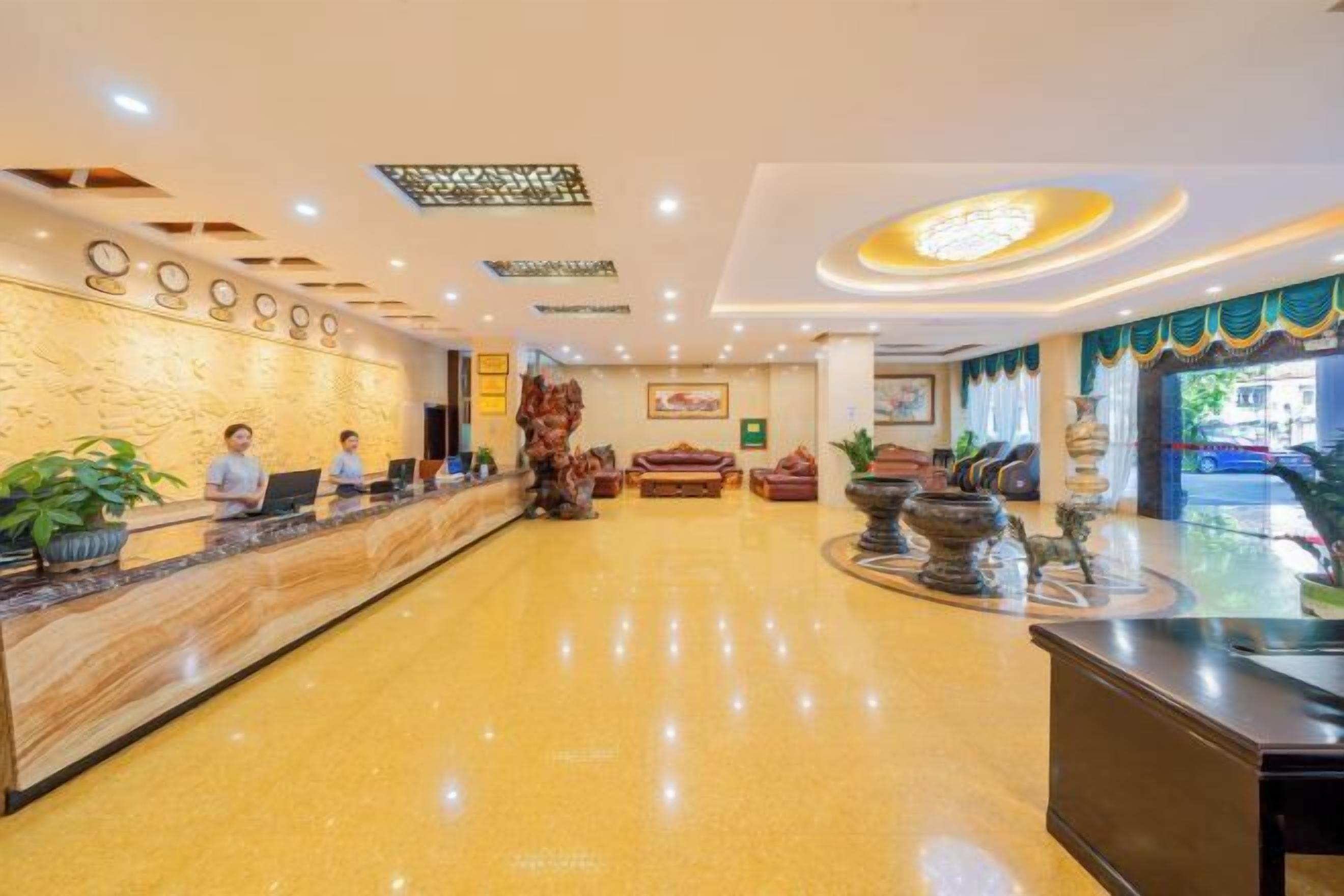 Un vestíbulo de hotel con mostrador de recepción, zona de estar y detalles decorativos.
