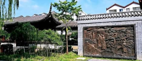 A traditional building with a tiled roof and a large mural.