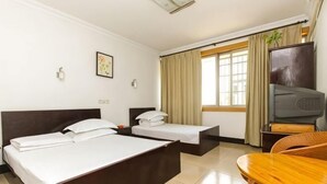 A hotel room with two beds, a television, a dining table, and a window with curtains. - Wan Fu Hostel (Kunshan)