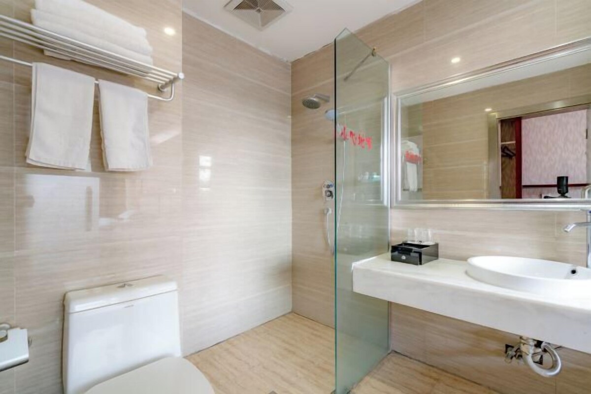 Une salle de bain moderne avec une douche à parois de verre, un lavabo blanc et des toilettes.