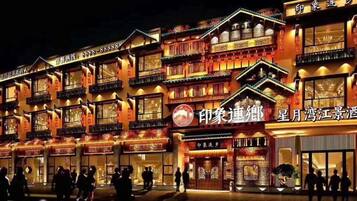 A traditional building with multiple balconies and illuminated signs, likely a hotel or restaurant.