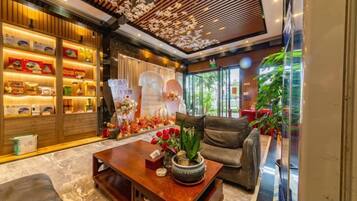A hotel lobby with a reception desk, seating area, and a display of local products.