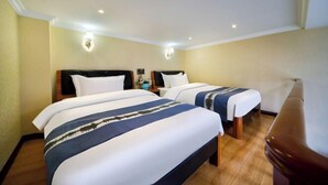 A hotel room with two beds, a wooden floor, and a ceiling light fixture. - Jin'an Hotel (Zhangye)