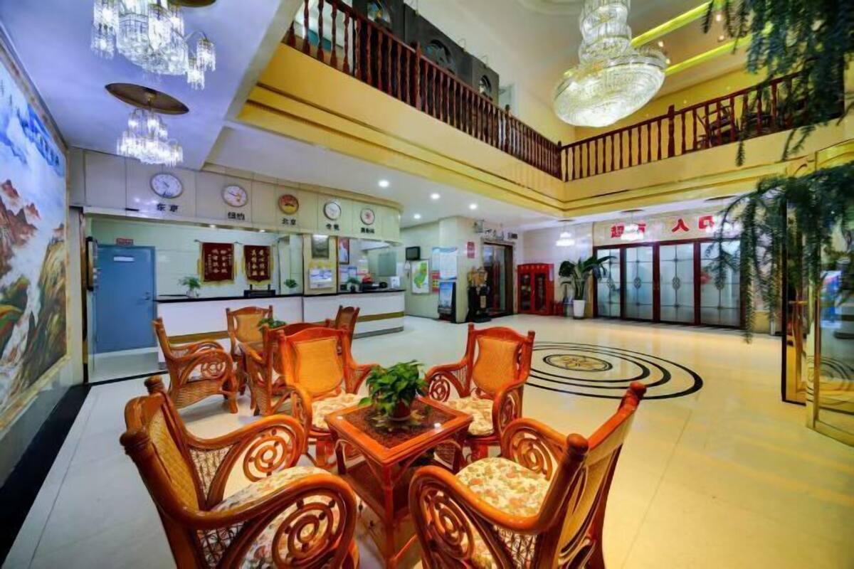 A lobby with a reception desk, seating area, and a staircase.