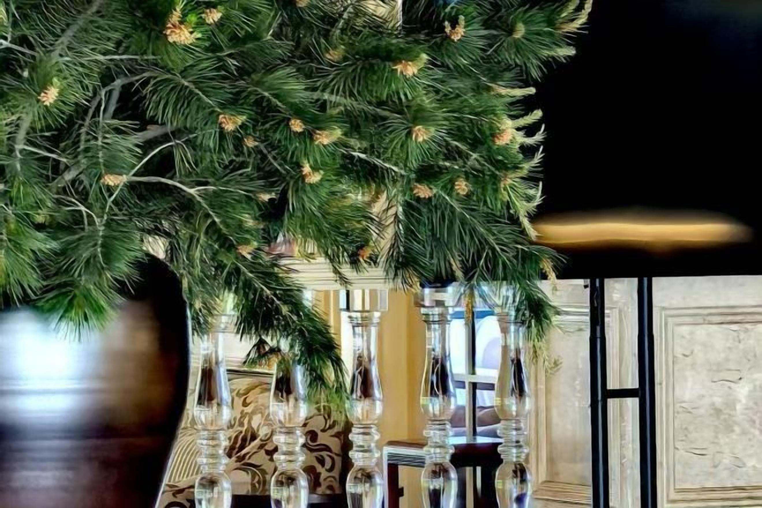 Ein Weihnachtsbaum mit Tannenzapfen, einer gemusterten Wand und einem Spiegel.