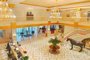 A hotel lobby with a central seating area, a staircase, and a chandelier. - Renji Hotel (Beijing)