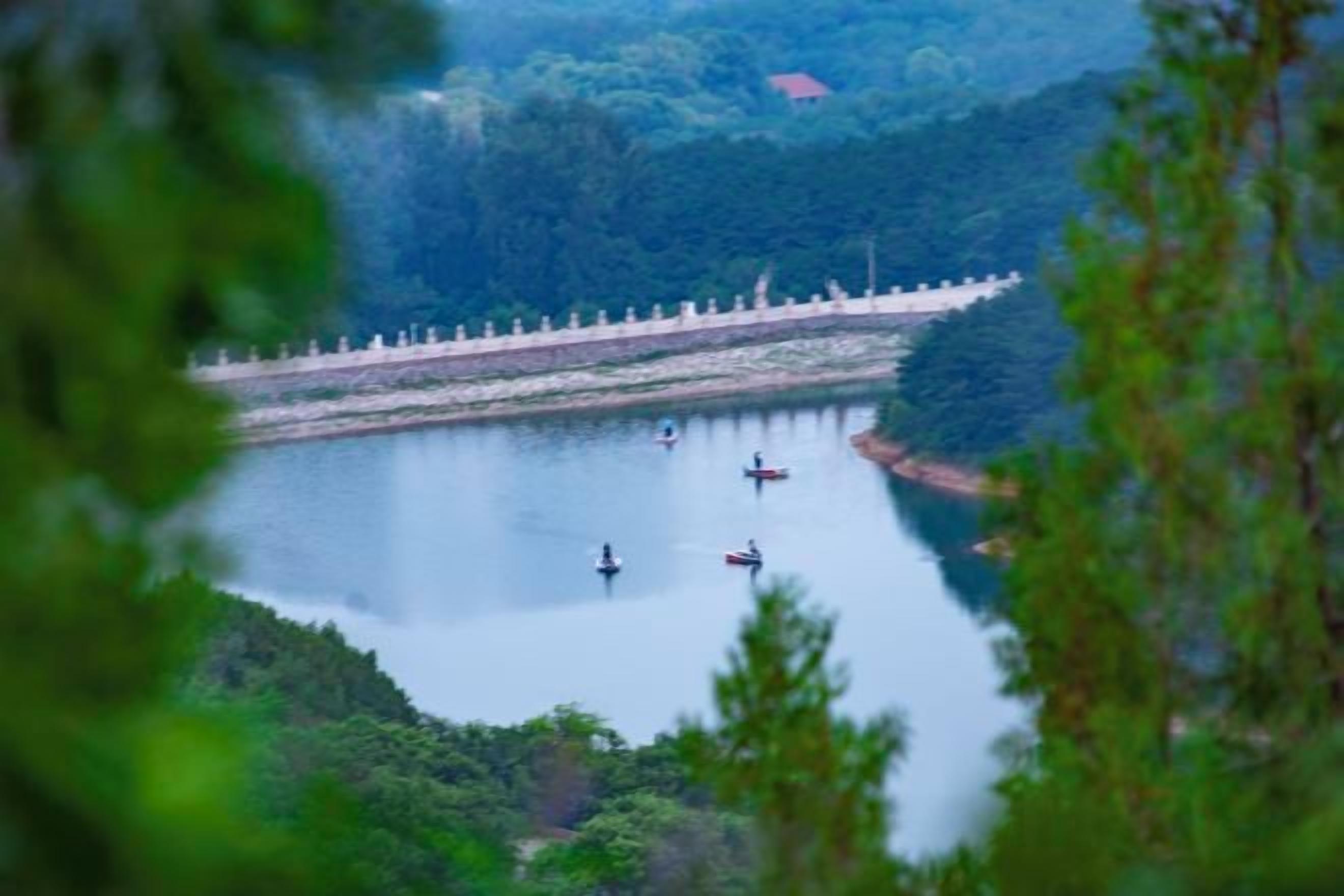 A lake with a dam and boats.