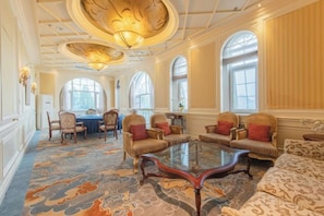 A spacious room with a large round table, several sofas, and a patterned carpet. - Renji Hotel (Beijing)