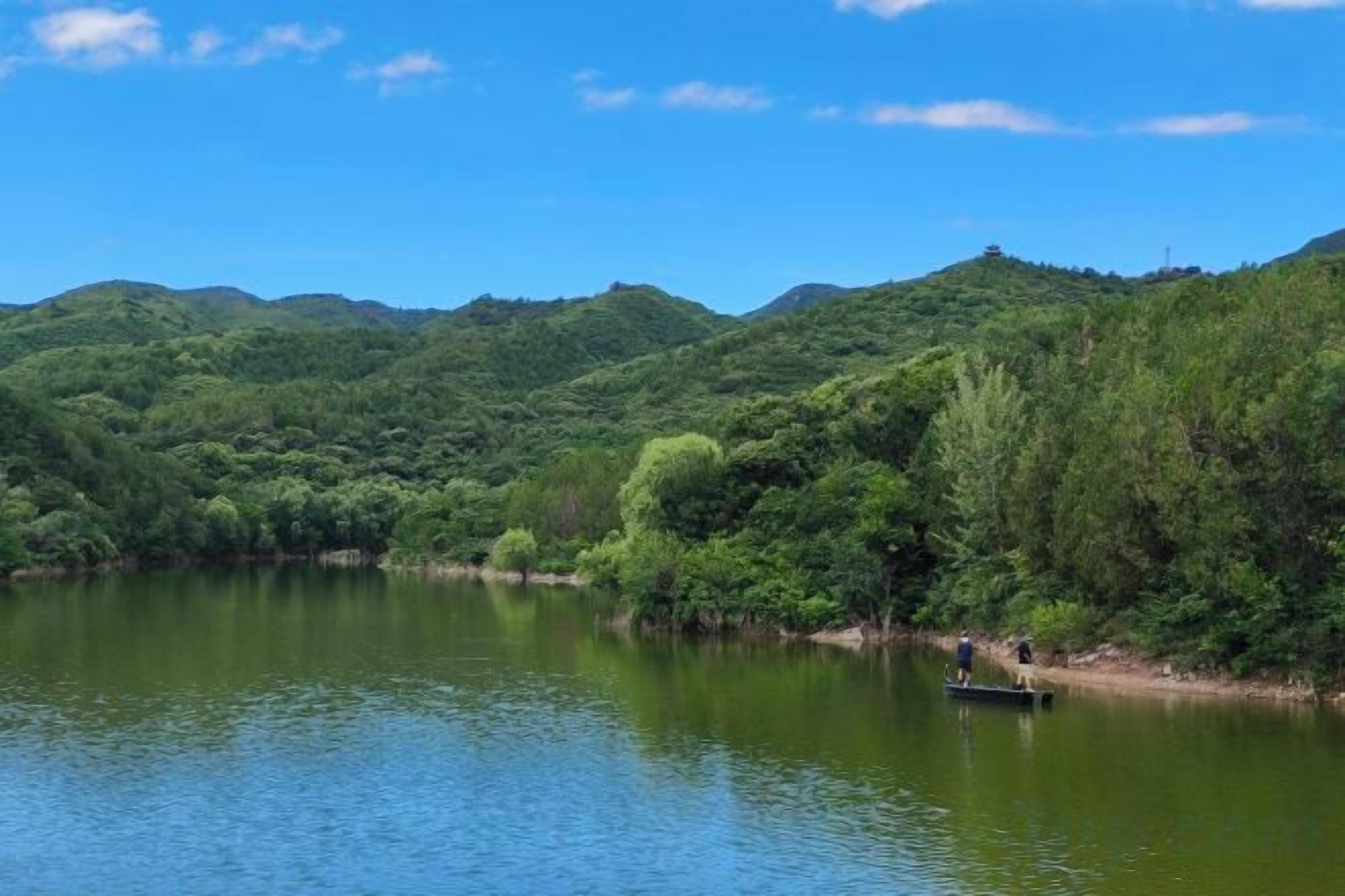 A calm lake surrounded by lush green hills.