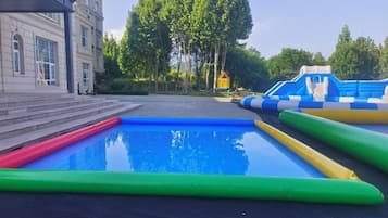 Una piscina con toboganes inflables y un edificio al fondo.
