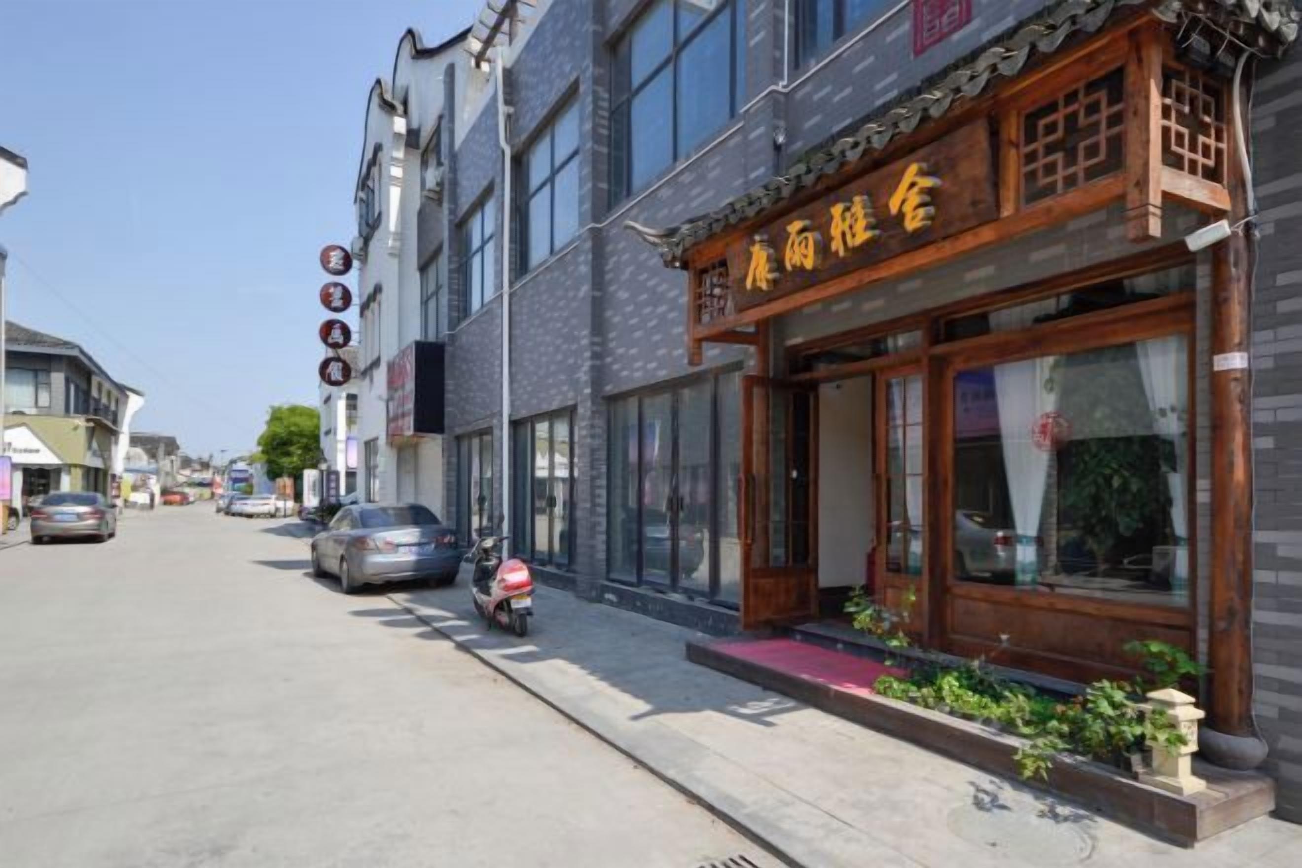 Un edificio chino tradicional con escaparate, una motocicleta estacionada y cielo despejado.