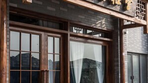A building with large wooden-framed windows and a brick facade. - Nanxun Kangyu Yashe Inn (Huzhou)