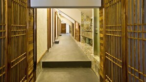 A corridor with wooden doors and a stone wall. - Nanxun Kangyu Yashe Inn (Huzhou)