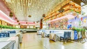 A spacious restaurant with high ceilings, hanging decorations, and a variety of seating arrangements including tables and chairs. - Xi Le Hui Hotel (Fujin)