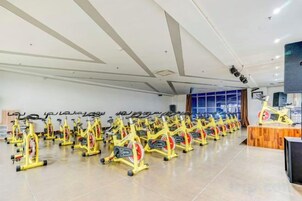 Un gimnasio con varias bicicletas estáticas dispuestas en filas.