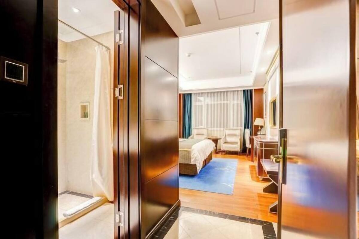 Quarto de hotel com uma cama, uma mesa e uma cadeira.