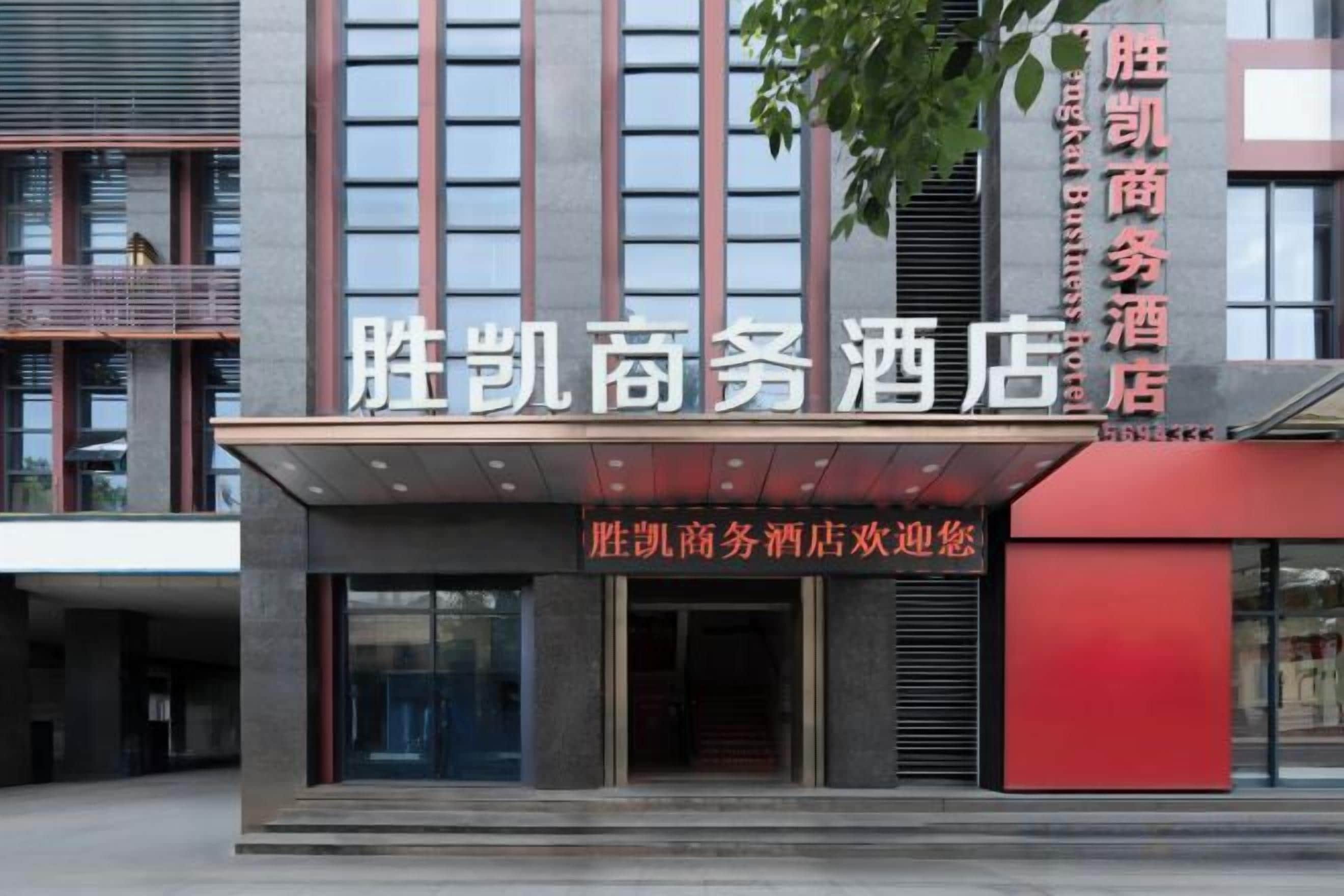 A hotel entrance with a modern facade, large windows, and a prominent sign.