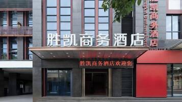 A hotel entrance with a modern facade, large windows, and a prominent sign.