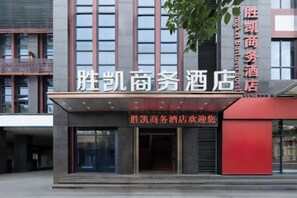 A hotel entrance with a modern facade, large windows, and a prominent sign. - Shengkai Business Hotel (Chongqing)