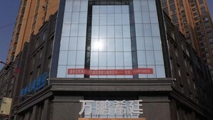 Un bâtiment d’hôtel doté d’une grande façade en verre et d’une enseigne indiquant « XING HOTEL ».