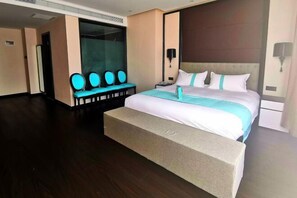 A modern hotel room with a large bed, a seating area with chairs, and a large window. - Wanpeng Xiting Hotel (Yanchuan)