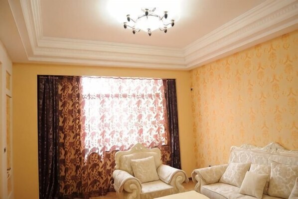 Una habitación con candelabro, un sofá y una silla.