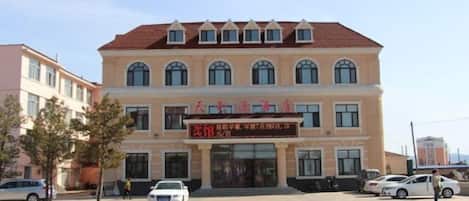 A multi-story building with a red-tiled roof and a signboard with Chinese characters.