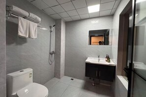 Moderni kylpyhuone, jossa on wc, suihku ja pesuallas.
