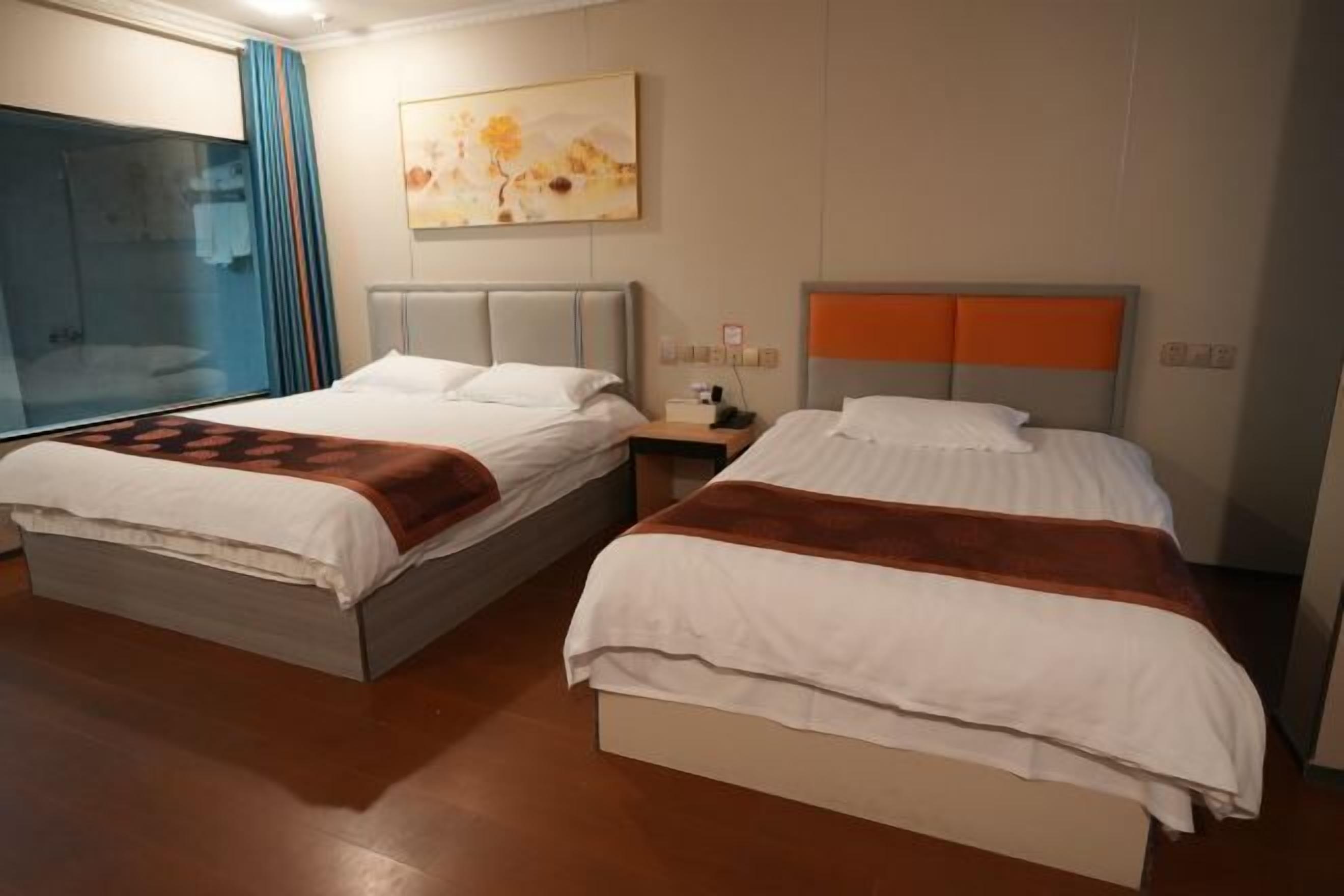 Twee bedden met hoofdborden, een schilderij aan de muur en een raam met gordijnen.