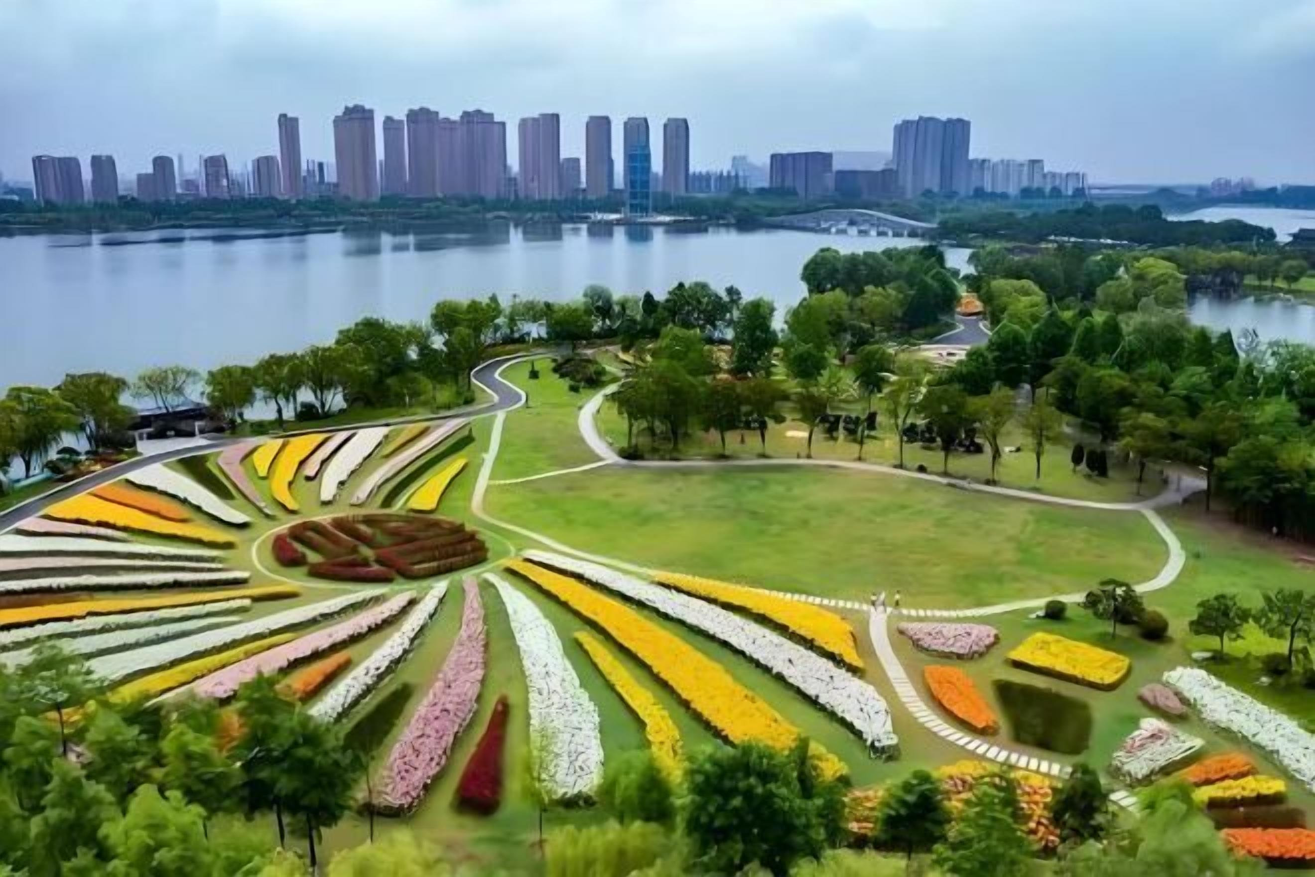 Um jardim ajardinado com vários canteiros de flores e um caminho curvo.