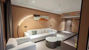 A modern living room with a white sofa, a coffee table, and a wall-mounted artwork. - China Inn (Donghai Xingfu Bridge) (Donghai)