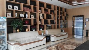 A modern lobby with a sofa set, a bookshelf, and a refrigerator. - China Inn (Donghai Xingfu Bridge) (Donghai)