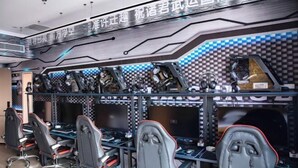 A gaming lounge with multiple gaming stations, each equipped with a chair, desk, and computer. - China Inn (Donghai Xingfu Bridge) (Donghai)