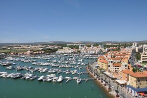 Boats docked in a bustling marina adjacent to a vibrant town.