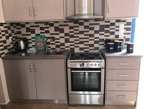 Kitchen features a double oven, stainless steel range hood, and checkered tile backsplash.