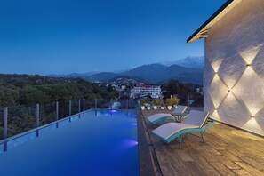 Una piscina al aire libre, tumbonas