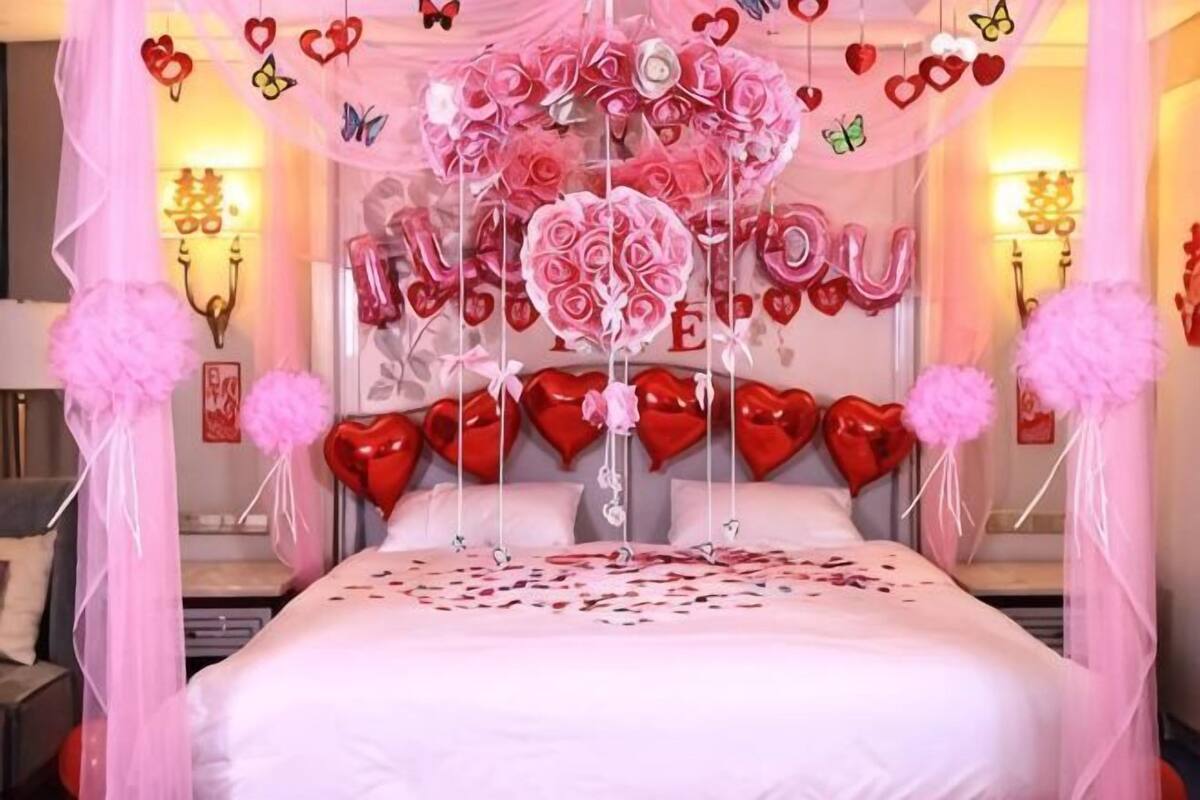 A bed with a canopy, heart-shaped decorations, and a wall with a heart-shaped design.