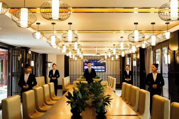 A conference room with a long table, multiple chairs, and hanging spherical light fixtures.
