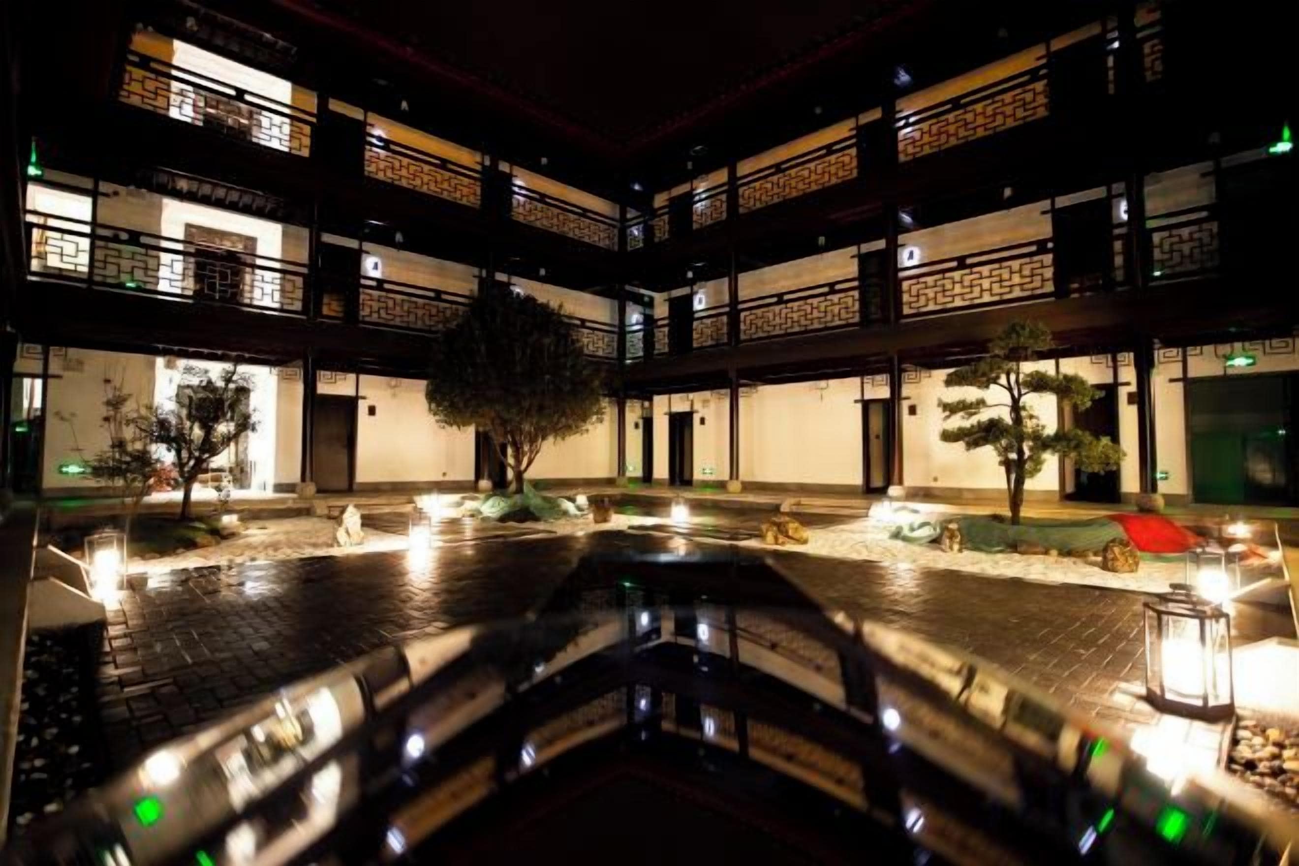 Un patio de varios niveles con una fuente central, rodeado por edificios de diseño arquitectónico tradicional.