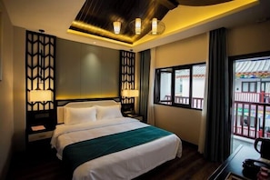 Habitación de hotel con una cama grande, dos mesitas de noche con lámparas, vista al balcón exterior y un diseño de techo moderno.