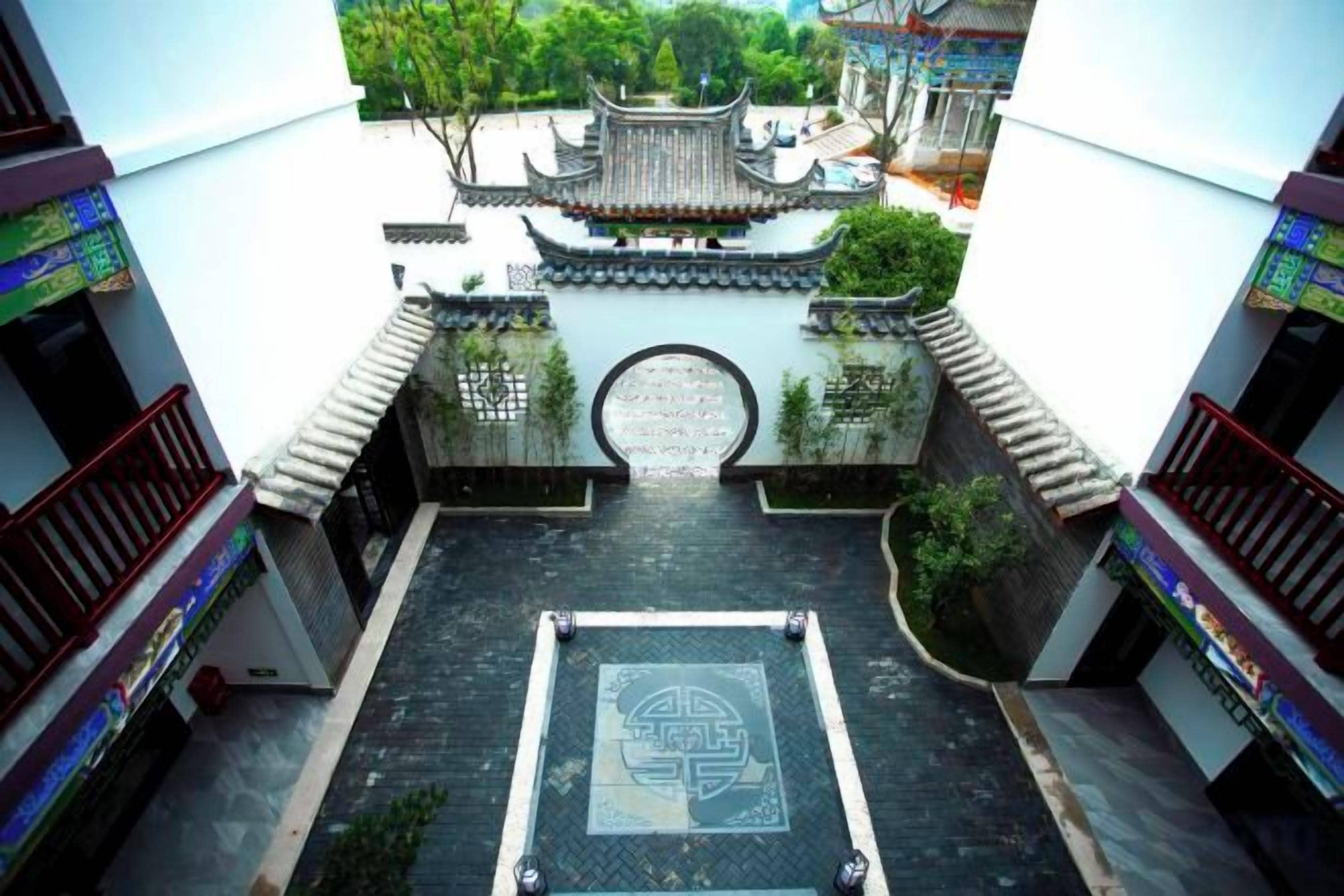Un patio con una reja tradicional, rodeado de edificios con balcones.