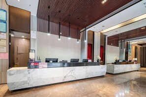 A reception area with a marble counter, wooden ceiling, and a red curtain in the background. - Ling Jiang Hotel (Yongtai)