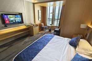 A hotel room with a bed, a desk, a chair, a TV, and a large window. - Ling Jiang Hotel (Yongtai)