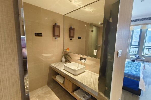 A modern bathroom with a large mirror, a white sink, and a towel rack. - Ling Jiang Hotel (Yongtai)