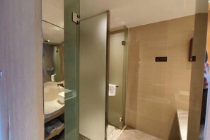A modern bathroom with a glass shower enclosure, a sink, and a mirror. - Ling Jiang Hotel (Yongtai)