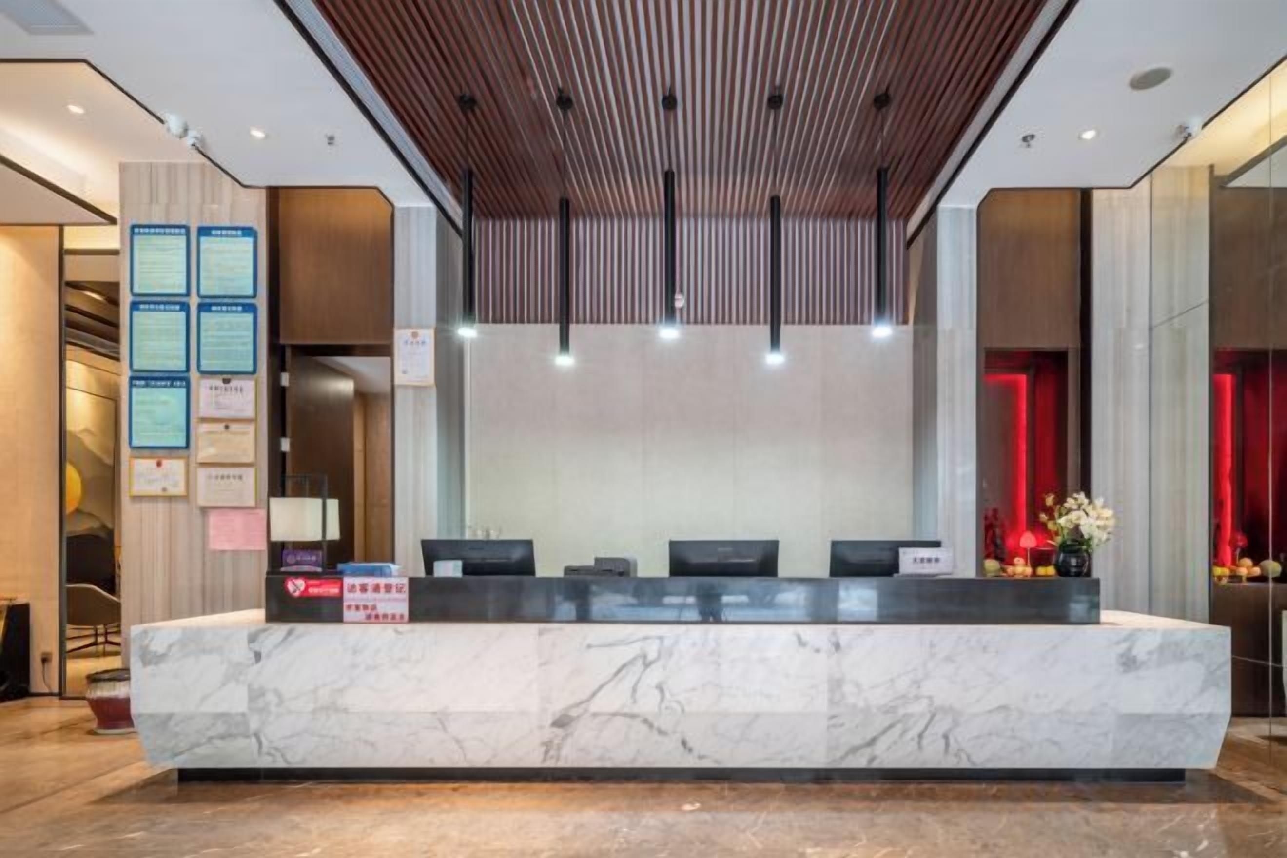 A reception desk with a marble top, multiple chairs, and a wooden ceiling.
