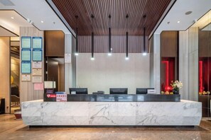 A reception desk with a marble top, multiple chairs, and a wooden ceiling.