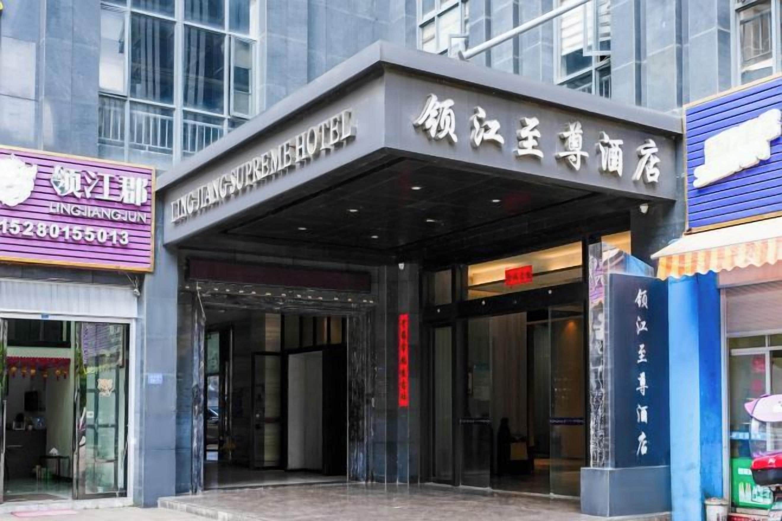 A hotel entrance with a covered entrance area and signage in a foreign language.